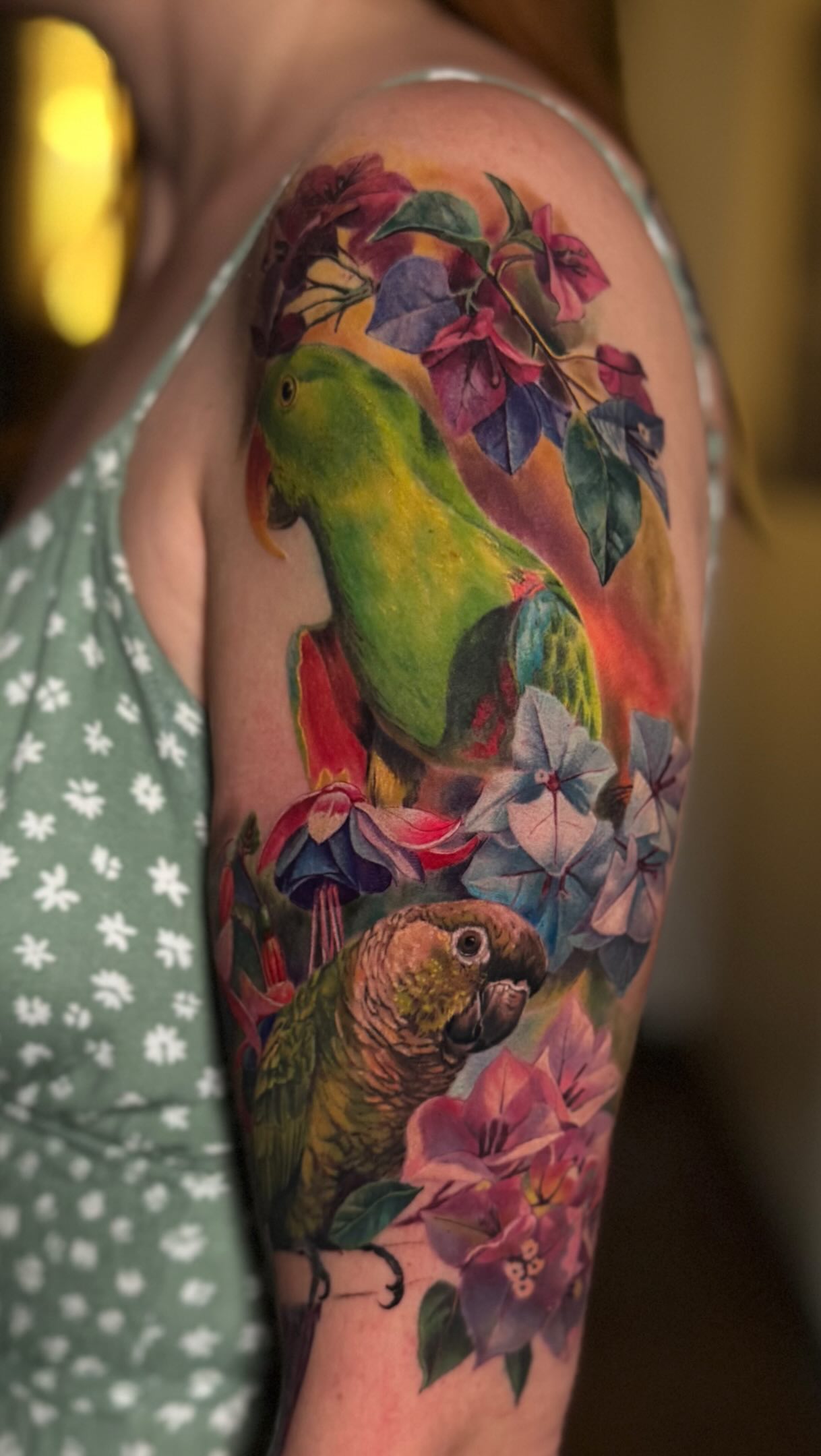 Colour realism tattoo sleeve with two parrots and tropical flowers by Julia Luniko in Winnipeg